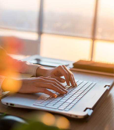 Personne tapant sur un ordinateur portable au lever du soleil