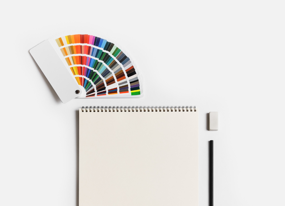 Carnet, nuancier de couleurs et crayon sur fond blanc minimaliste