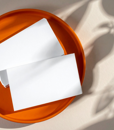 Flyers blancs format paysage posé sur un plateau rond orange