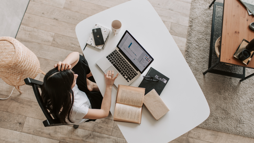 femme vue du ciel qui fait ses recherches sur son ordinateur