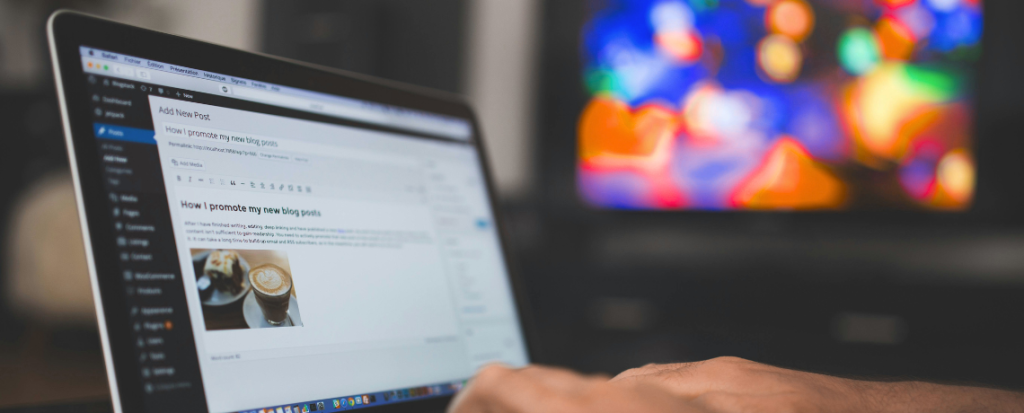 homme qui tape sur son clavier d'ordinateur et qui rédige un article sur Wordpress